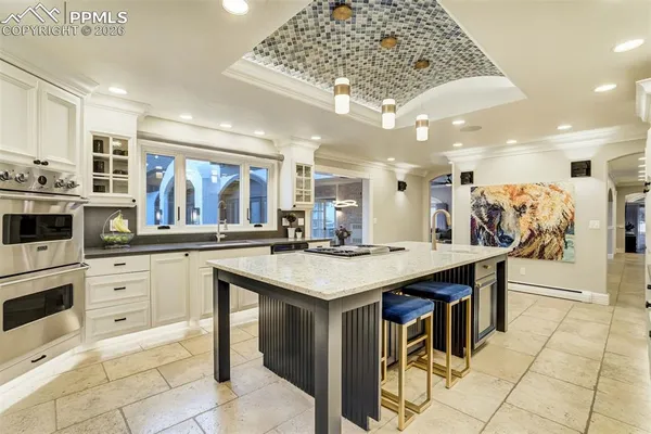 a kitchen with stainless steel appliances granite countertop a table chairs sink and cabinets