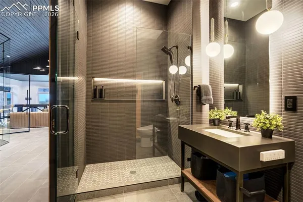 a bathroom with a sink a toilet and shower