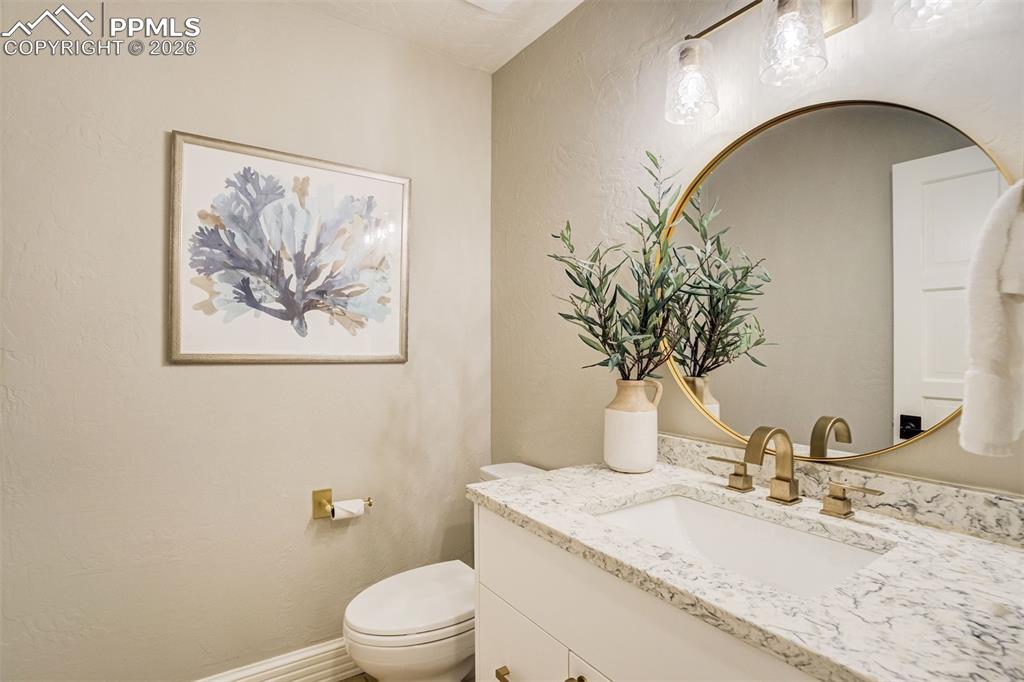 17 Pourtales Road Colorado Springs, CO 80906 - Photo 27 of 50 a bathroom with a granite countertop sink a toilet and mirror