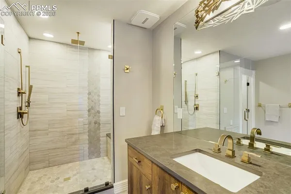 a bathroom with a granite countertop sink mirror and shower
