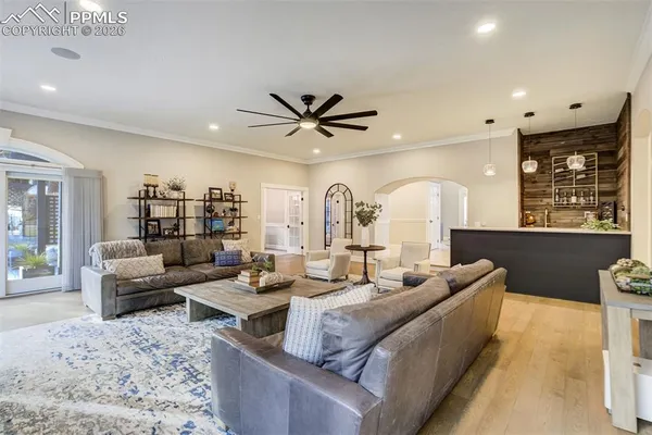 a living room with furniture and a large window with wooden floor