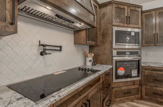 a kitchen with stainless steel appliances granite countertop a refrigerator and a sink