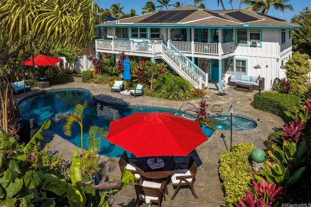 an aerial view of a house roof deck with couches table and chairs under an umbrella
