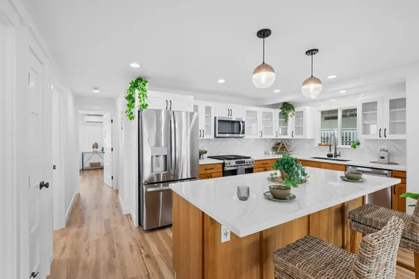 a kitchen with stainless steel appliances granite countertop a sink a stove and refrigerator