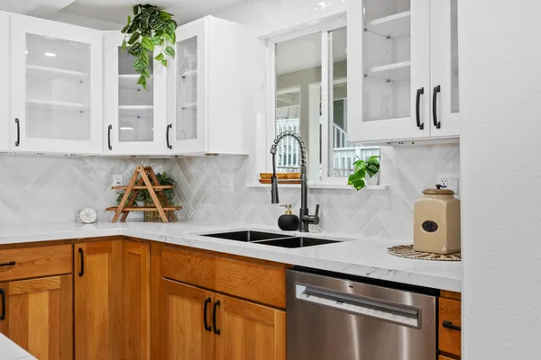 a kitchen with stainless steel appliances granite countertop a sink and a white cabinets