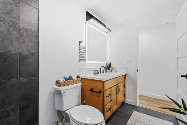 a bathroom with a sink a toilet and mirror