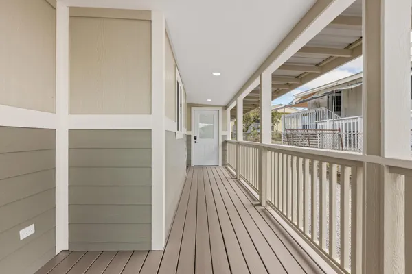 a view of a balcony with wooden floor and fence