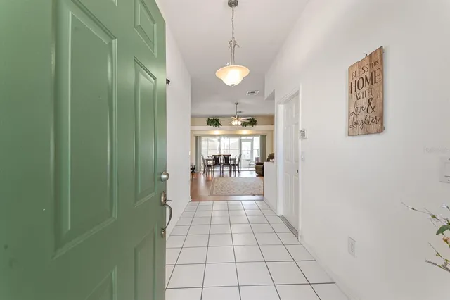a view of a hallway with wooden floor and a bathroom