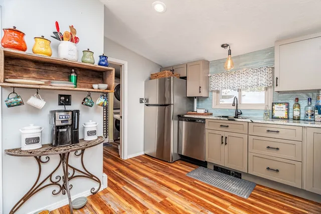 a kitchen with stainless steel appliances granite countertop a stove a sink and a microwave