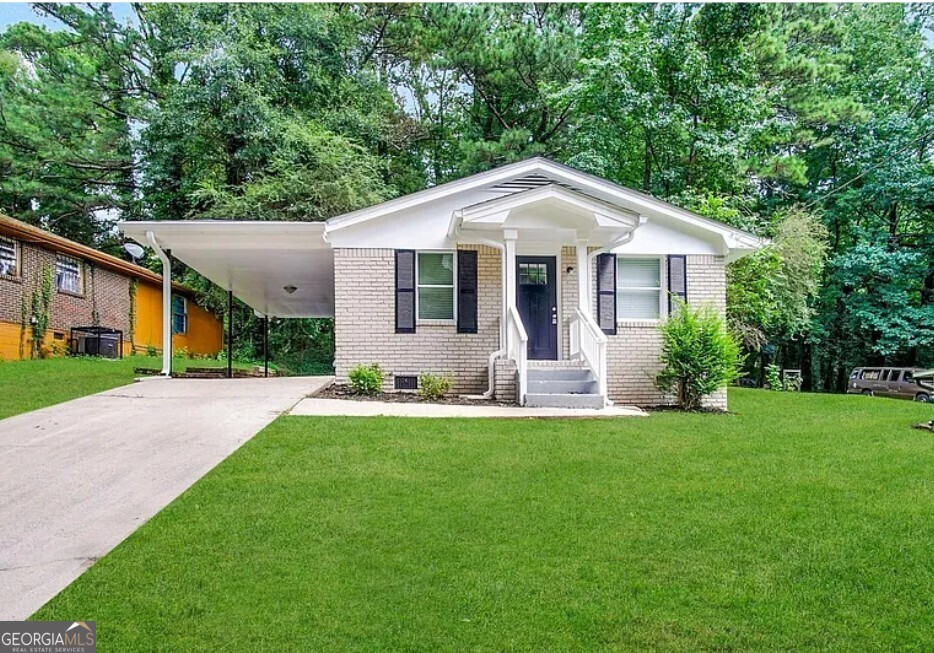 a front view of a house with a yard and trees