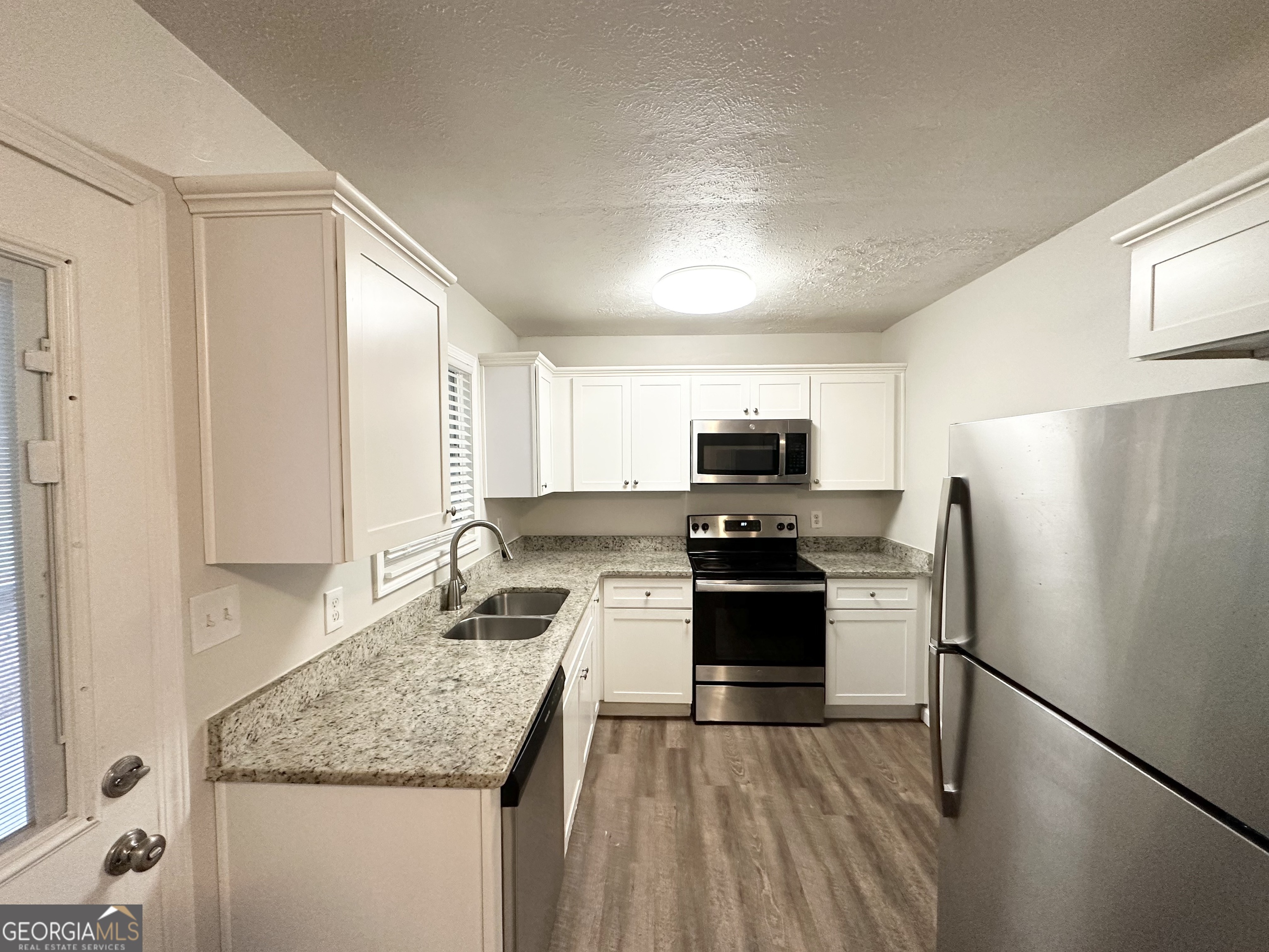 2930 Waters Road Southwest Atlanta, GA 30354 - Photo 5 of 14 a kitchen with stainless steel appliances granite countertop a refrigerator stove microwave and sink