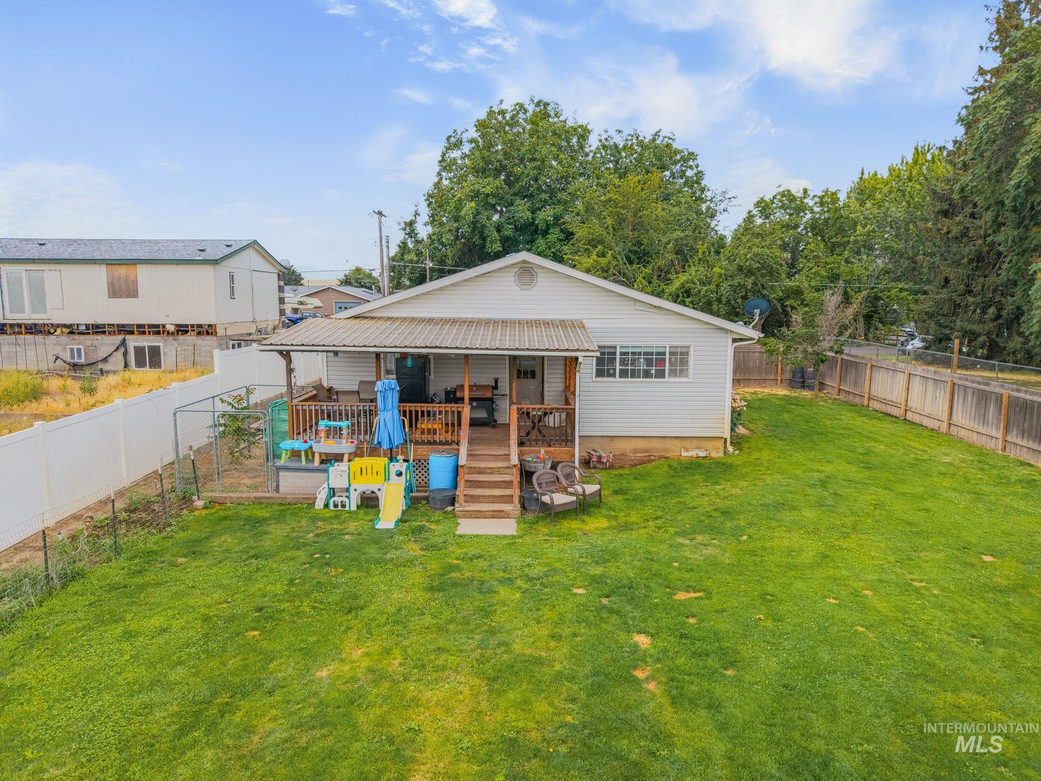 2119 Ripon Avenue Lewiston, ID 83501 - Photo 32 of 50 Expansive backyard featuring a manicured lawn, a covered wooden deck, and mature trees providing natural screening