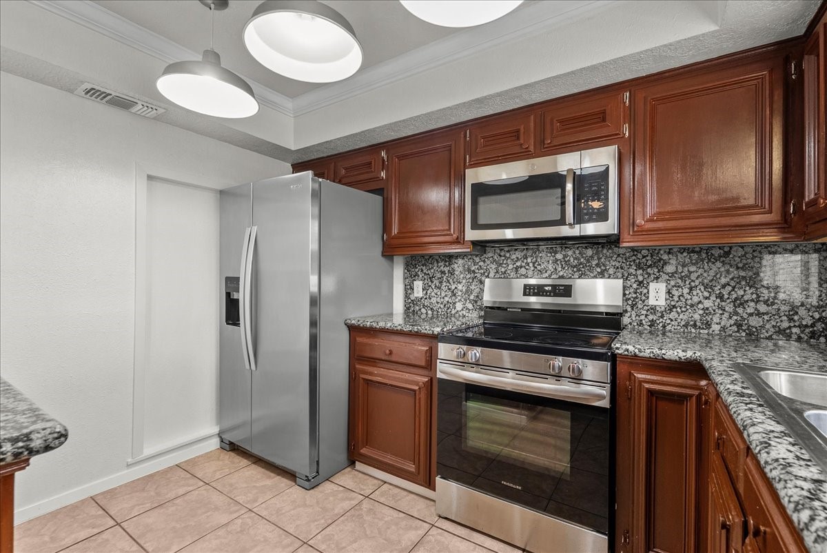430 Redway Lane Houston, TX 77598 - Photo 22 of 43 a kitchen with stainless steel appliances granite countertop a stove a refrigerator and a microwave