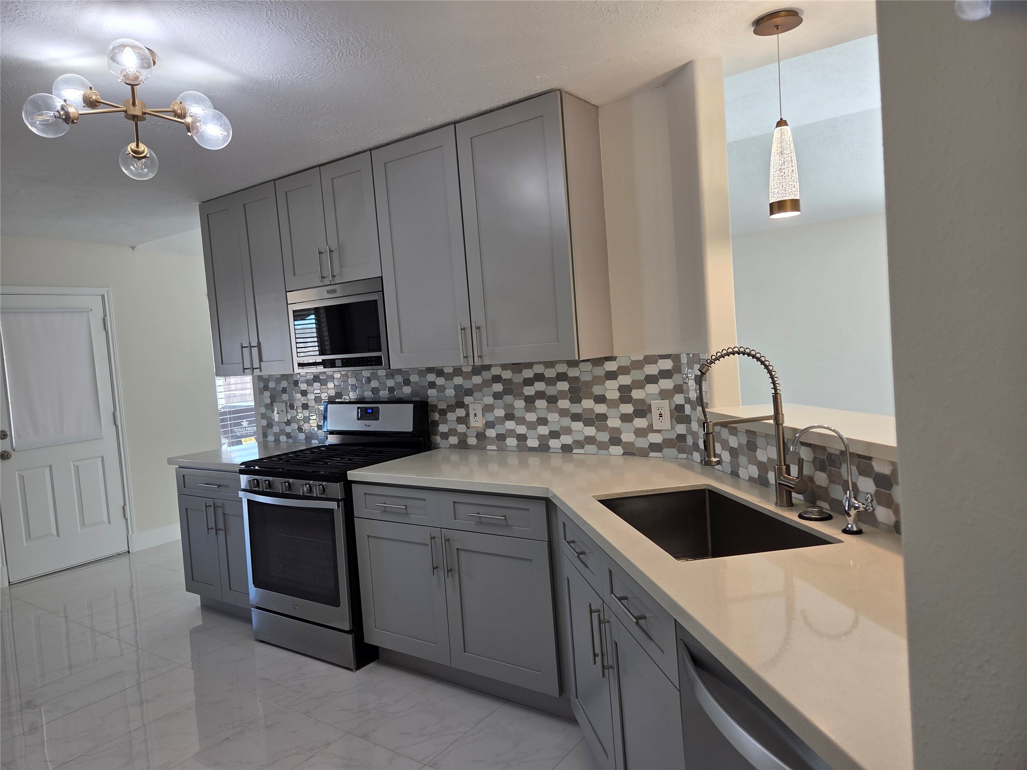 7019 Brody Lane Houston, TX 77083 - Photo 4 of 26 a kitchen with a sink stove and microwave