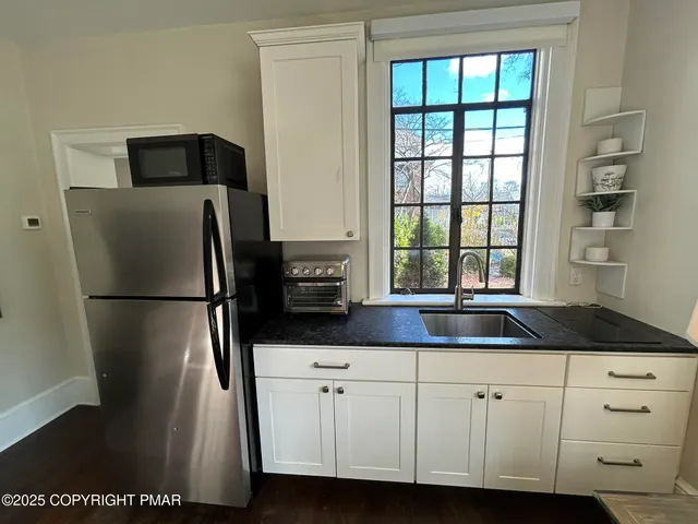 a kitchen with appliances a counter space and a window