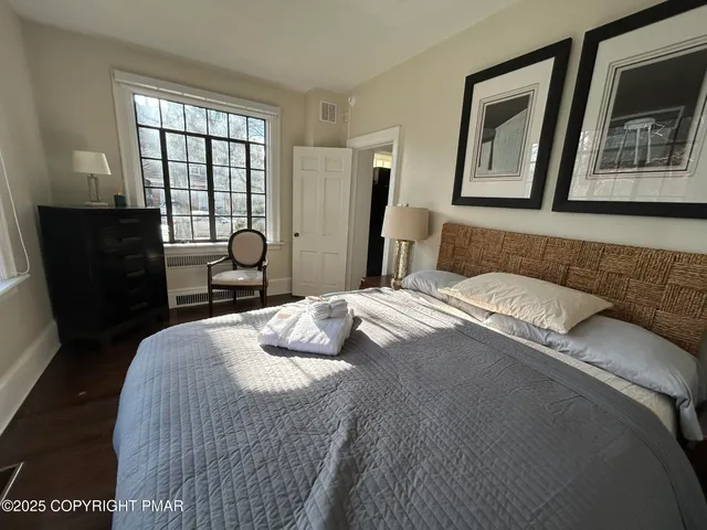 a bedroom with a bed mirror and window