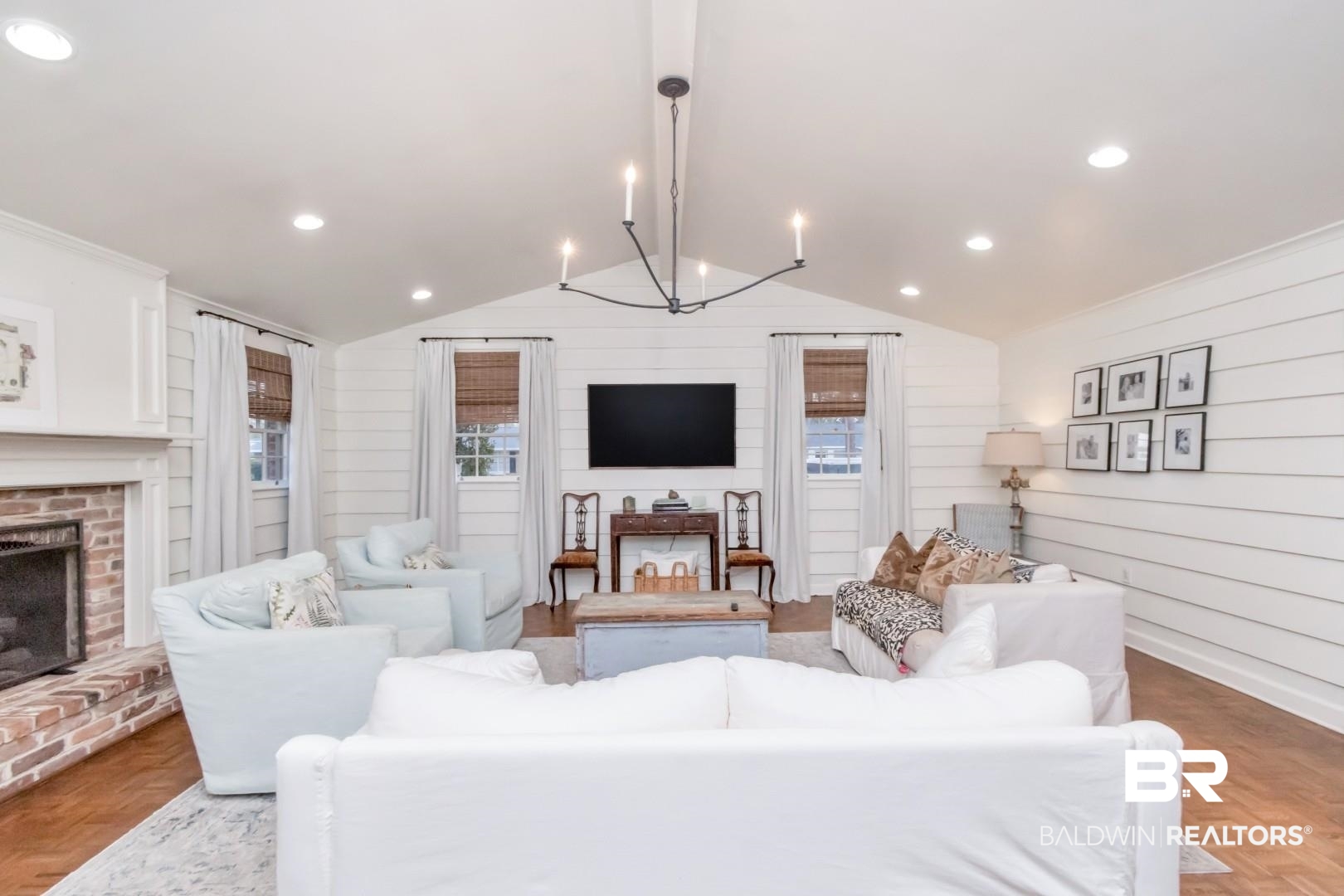 154 Fenwick Road Mobile, AL 36608 - Photo 6 of 48 Living area featuring parquet floors, a brick fireplace, a chandelier, and wooden walls