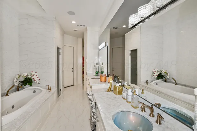 a bathroom with a granite countertop tub sink and mirror