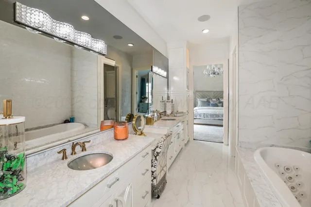 a bathroom with a granite countertop sink and a large mirror