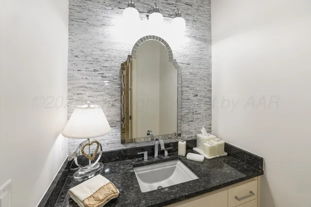 a bathroom with a granite countertop sink and a mirror