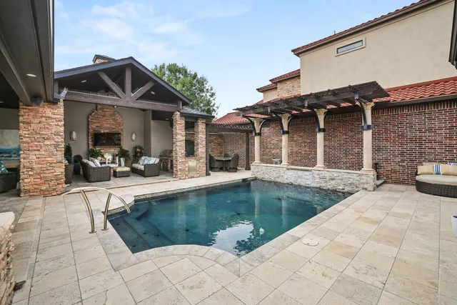 a view of a house with swimming pool and sitting area