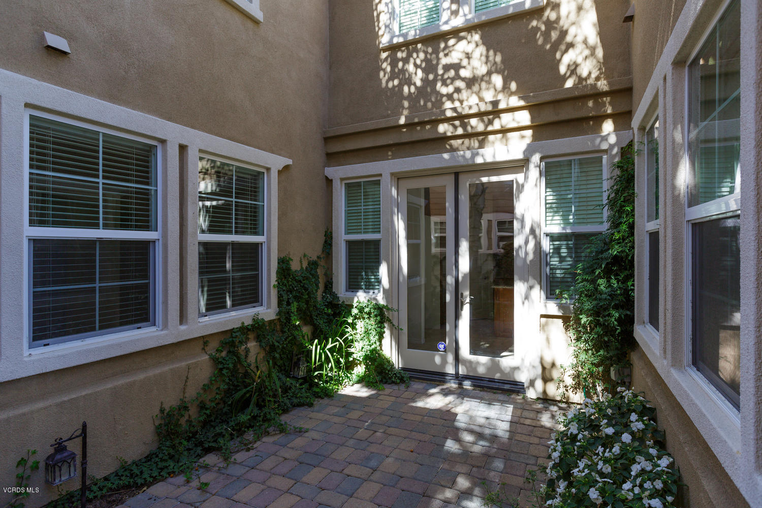 1455 Donegal Way Oxnard, CA 93035 - Photo 26 of 32 a view of a brick house with a large windows and plants