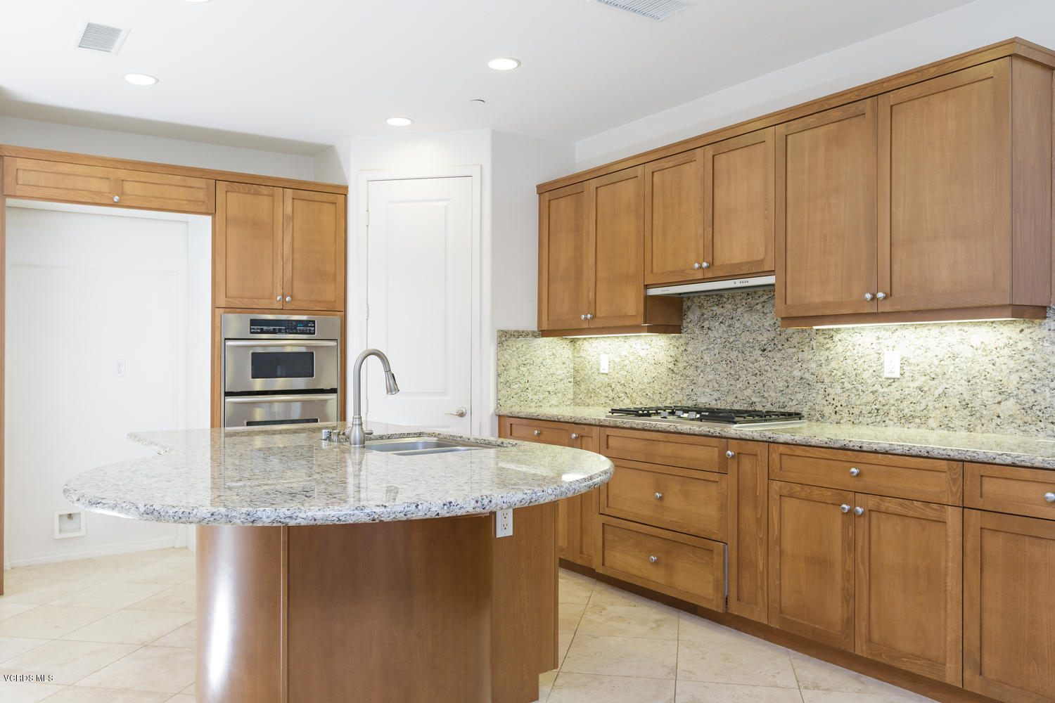 1455 Donegal Way Oxnard, CA 93035 - Photo 7 of 32 a kitchen with kitchen island granite countertop a stove sink and cabinets