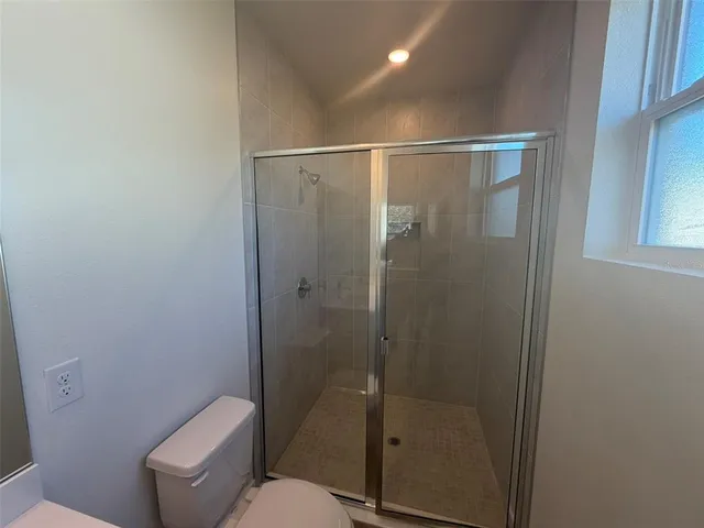 a bathroom with a toilet and a shower