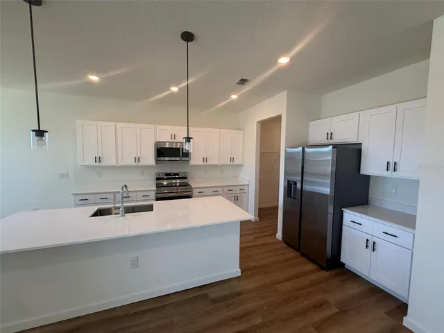 a kitchen with stainless steel appliances a refrigerator sink and microwave