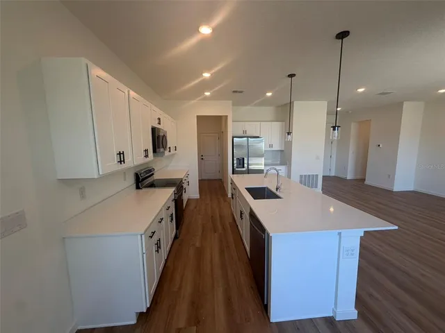 a kitchen with kitchen island a sink stove and refrigerator