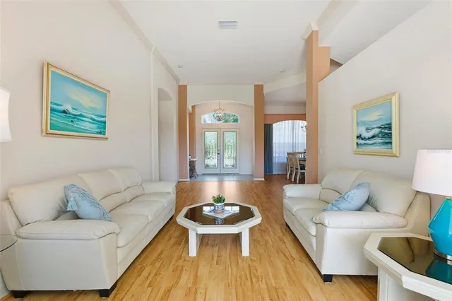 a view of a dining room with furniture a chandelier and wooden floor