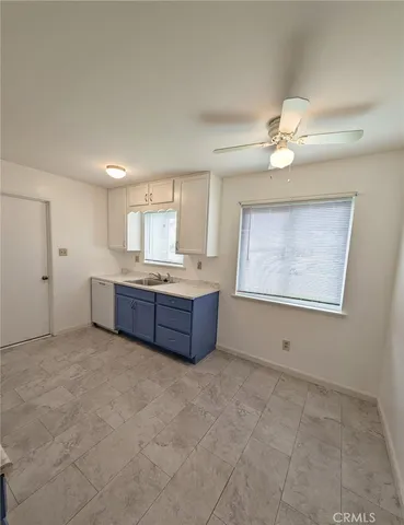 a living room with stainless steel appliances kitchen island granite countertop furniture and a ceiling fan