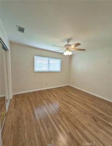 a view of a room with wooden floor and a chandelier