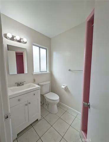 a bathroom with a toilet a sink a mirror a vanity and window