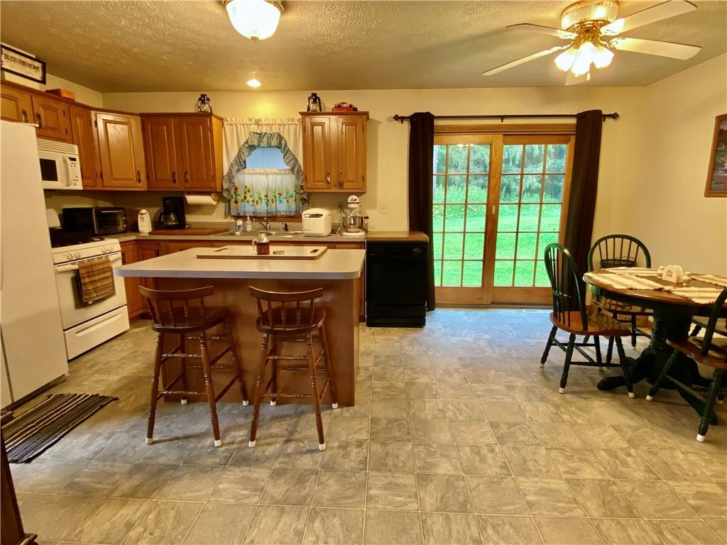 1564 Hells Kitchen Road Polk, PA 16342 - Photo 8 of 25 a kitchen with kitchen island a dining table and chairs