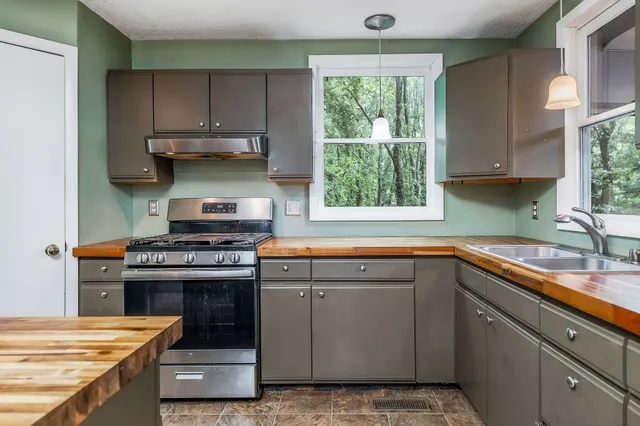a kitchen with a stove a sink and a window