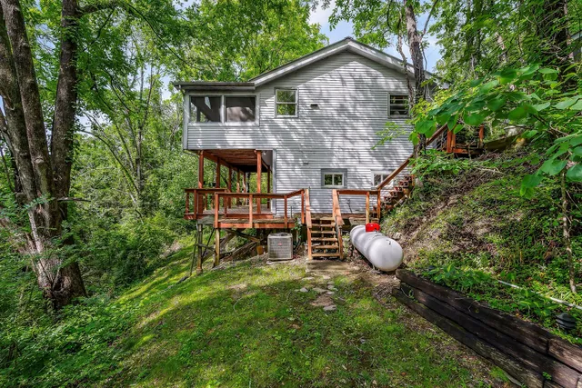 a backyard of a house with table and chairs under an umbrella