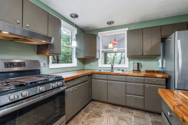 a kitchen with stainless steel appliances granite countertop a stove a sink dishwasher and cabinets with wooden floor