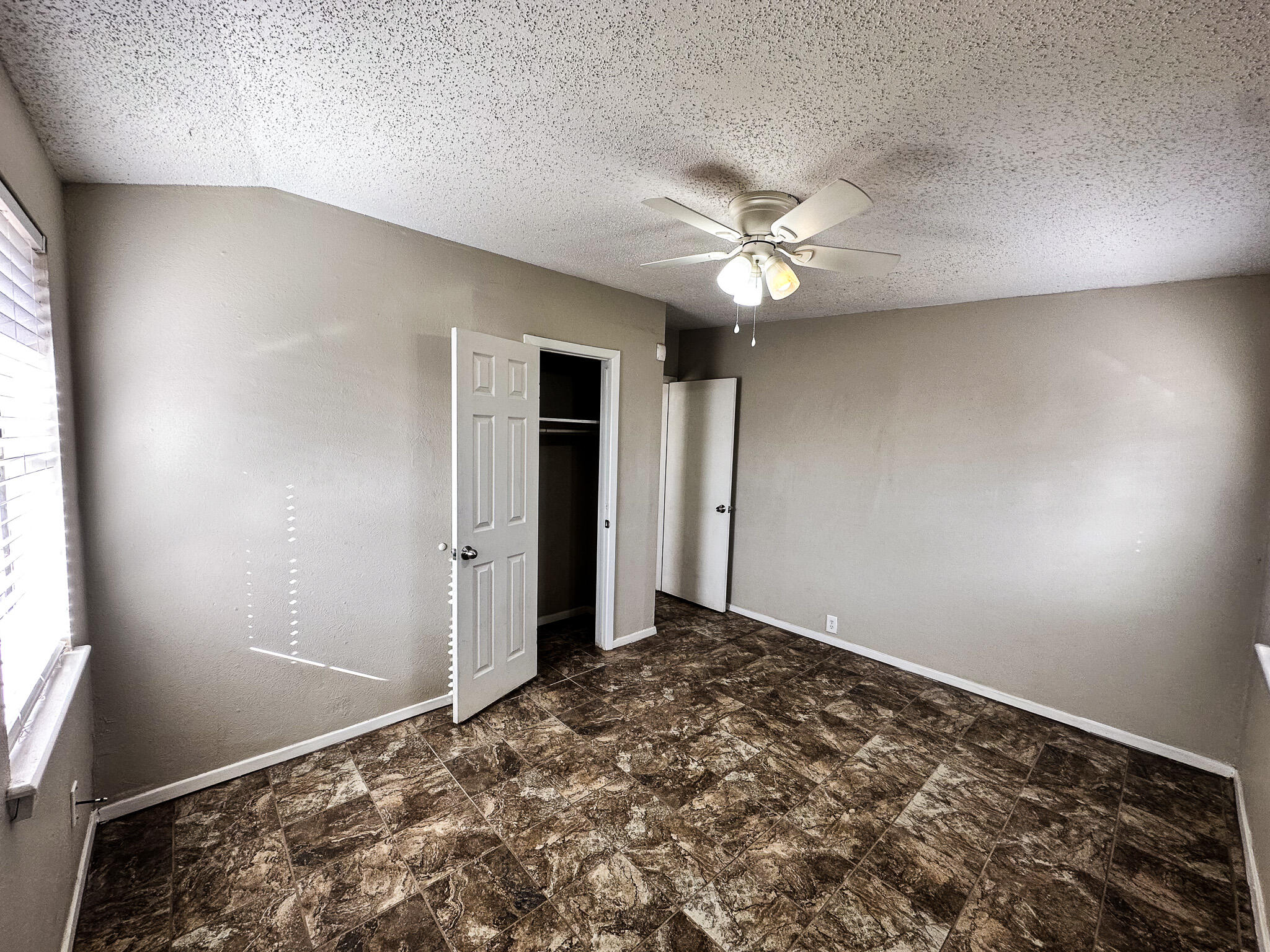 2101 48th Street Lubbock, TX 79412 - Photo 17 of 36 an empty room with a window and a ceiling fan