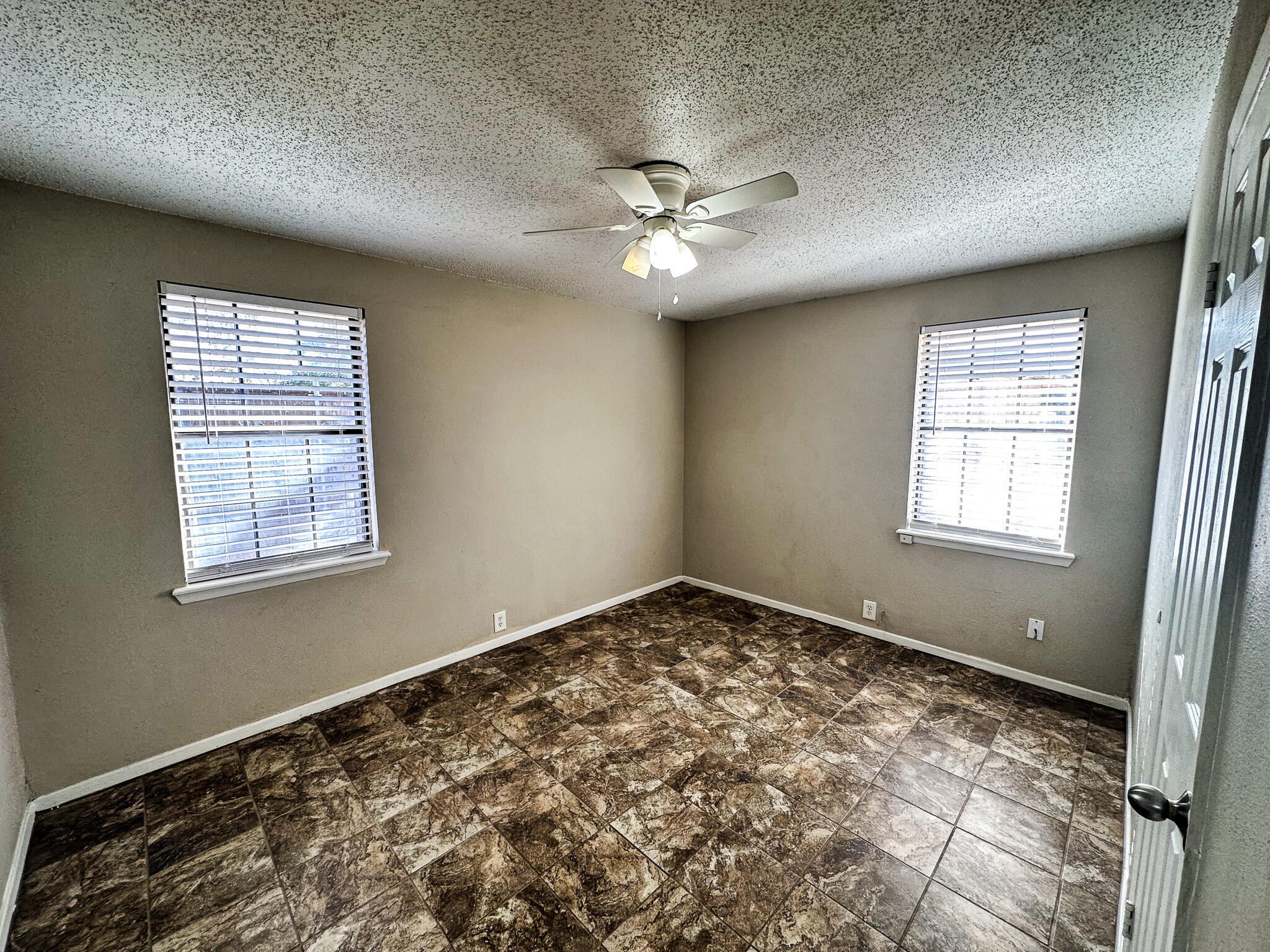 2101 48th Street Lubbock, TX 79412 - Photo 18 of 36 a view of a big room with windows and chandelier fan
