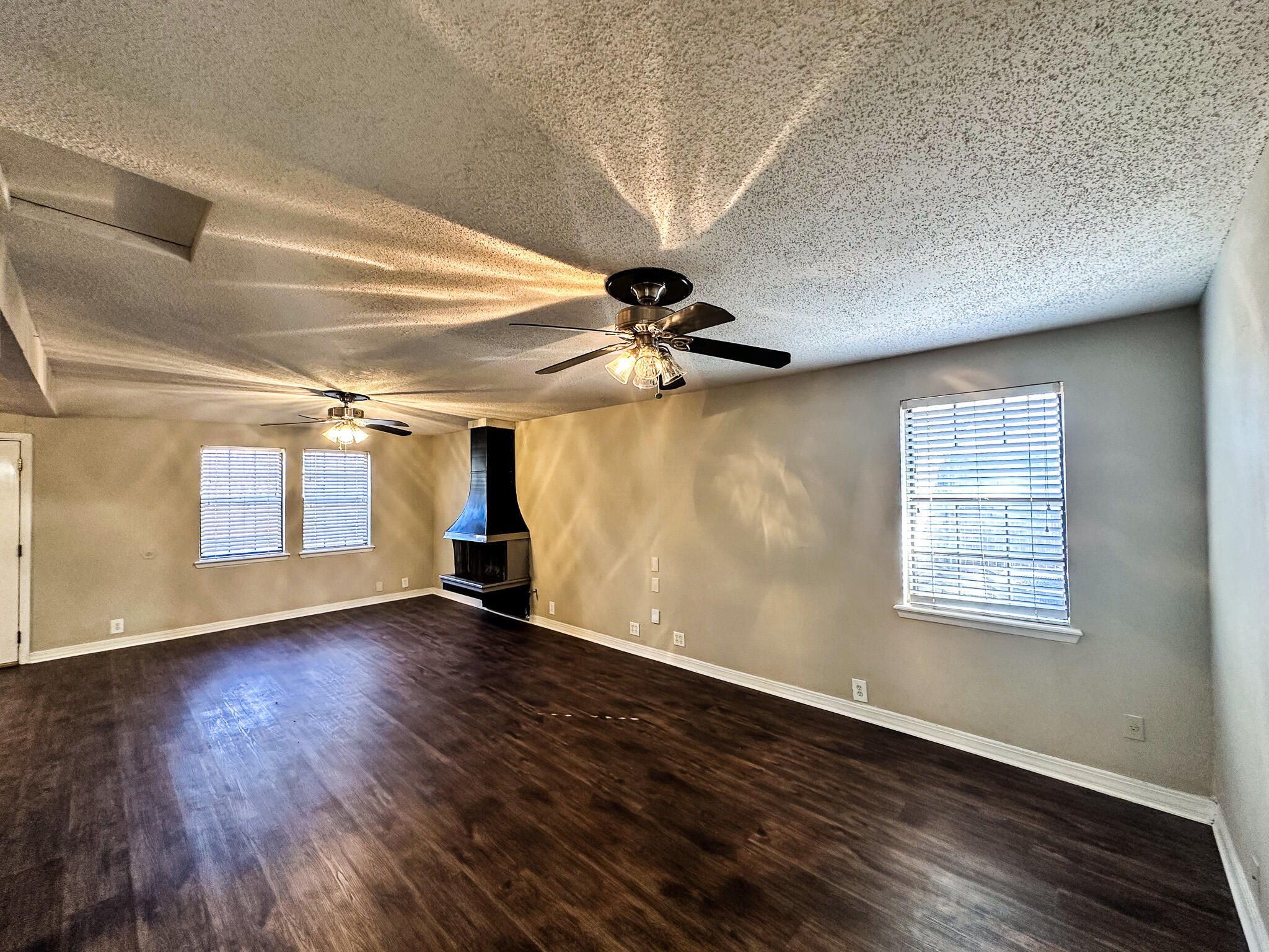 2101 48th Street Lubbock, TX 79412 - Photo 5 of 36 a view of an empty room with wooden floor and a window