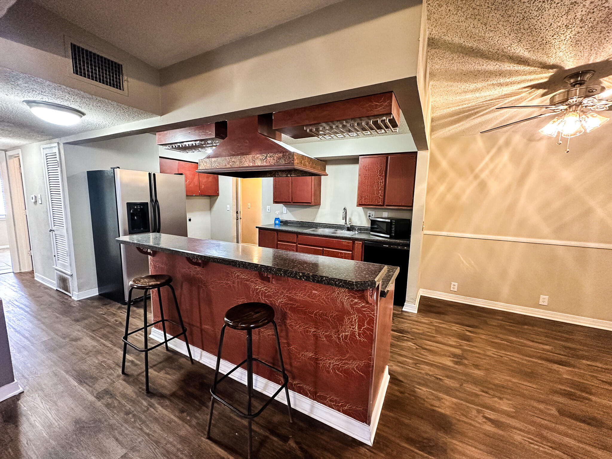 2101 48th Street Lubbock, TX 79412 - Photo 9 of 36 a kitchen with stainless steel appliances granite countertop a table chairs in it and wooden floors