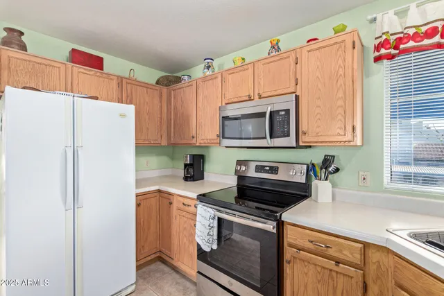 a kitchen with granite countertop a refrigerator stove and microwave