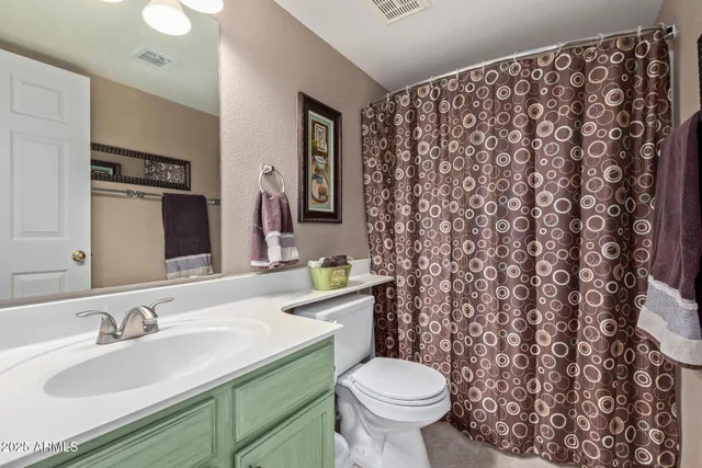 a bathroom with a granite countertop sink and a toilet