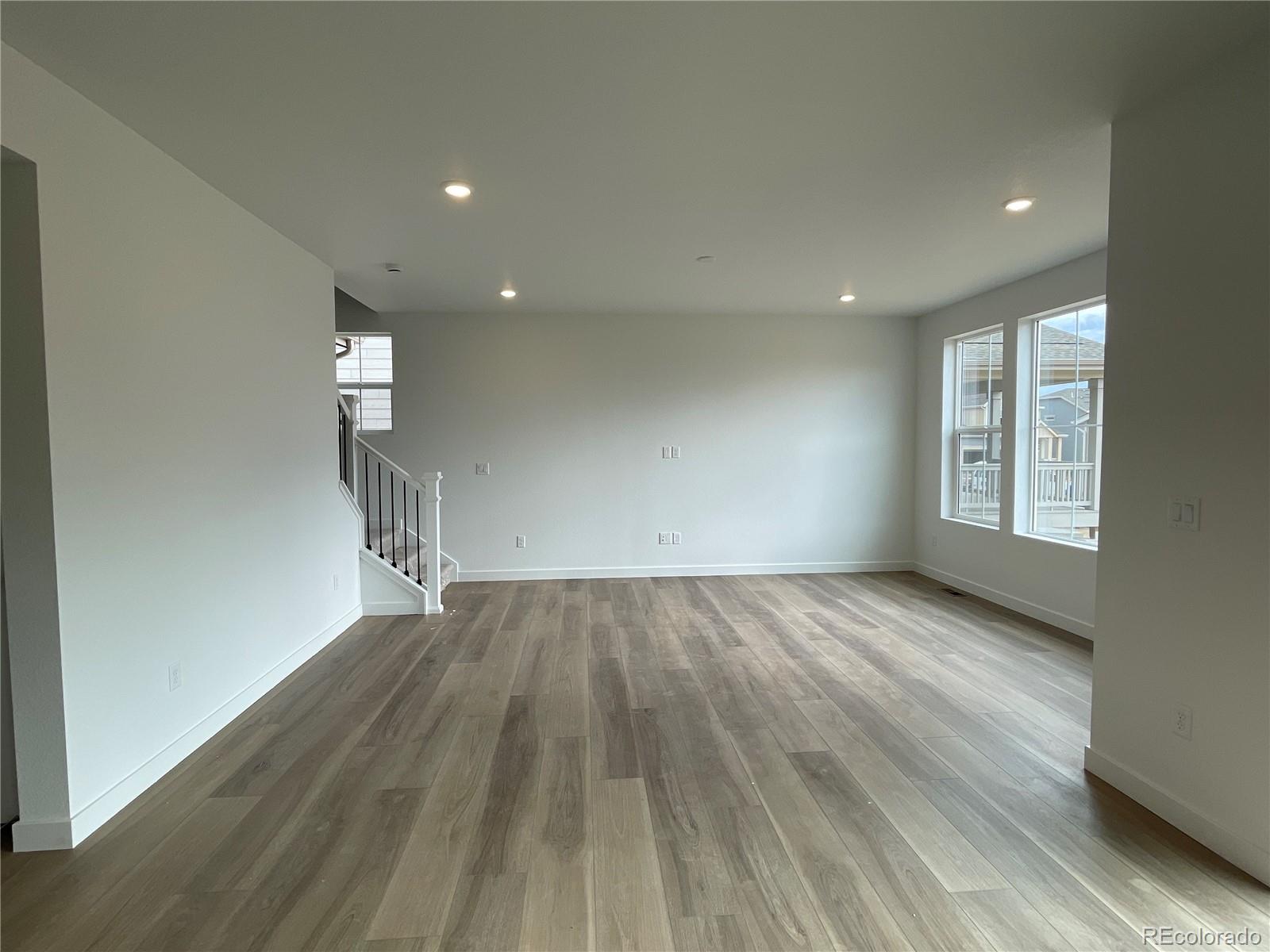 12880 Range Street Firestone, CO 80504 - Photo 4 of 21 an empty room with wooden floor and windows