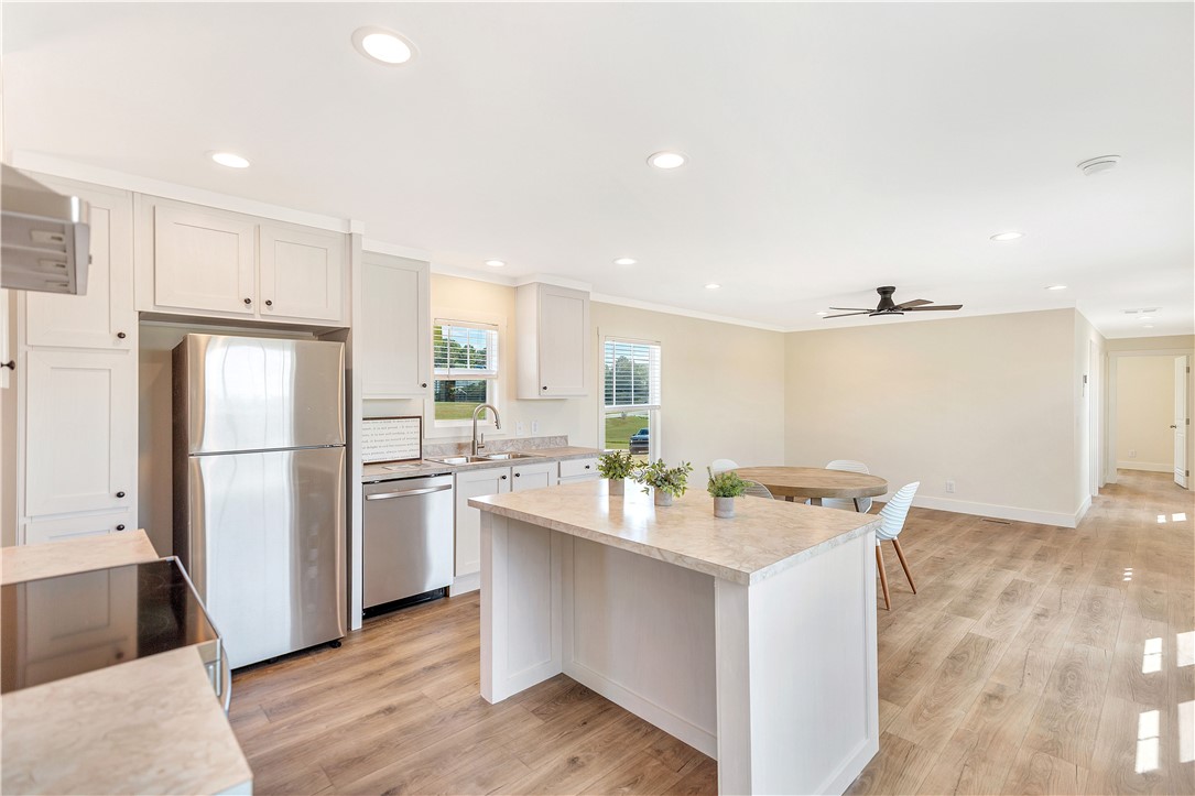 205 Wade Farm Road Fair Play, SC 29643 - Photo 23 of 23 An open floorplan seamlessly connects the modern kitchen and dining area over rich wood flooring.