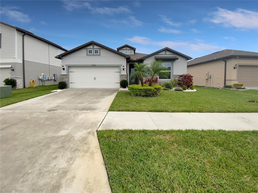 9793 Rally Spring Loop Wesley Chapel, FL 33545 - Photo 1 of 1 a front view of a house with a yard and garage