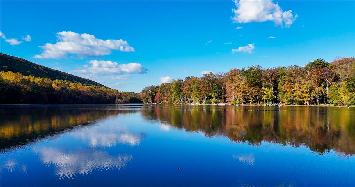 18 White Oak Road Nesquehoning, PA 18240 - Photo 48 of 52 A tranquil lake mirrors the clear blue sky and a vibrant autumn tree line.