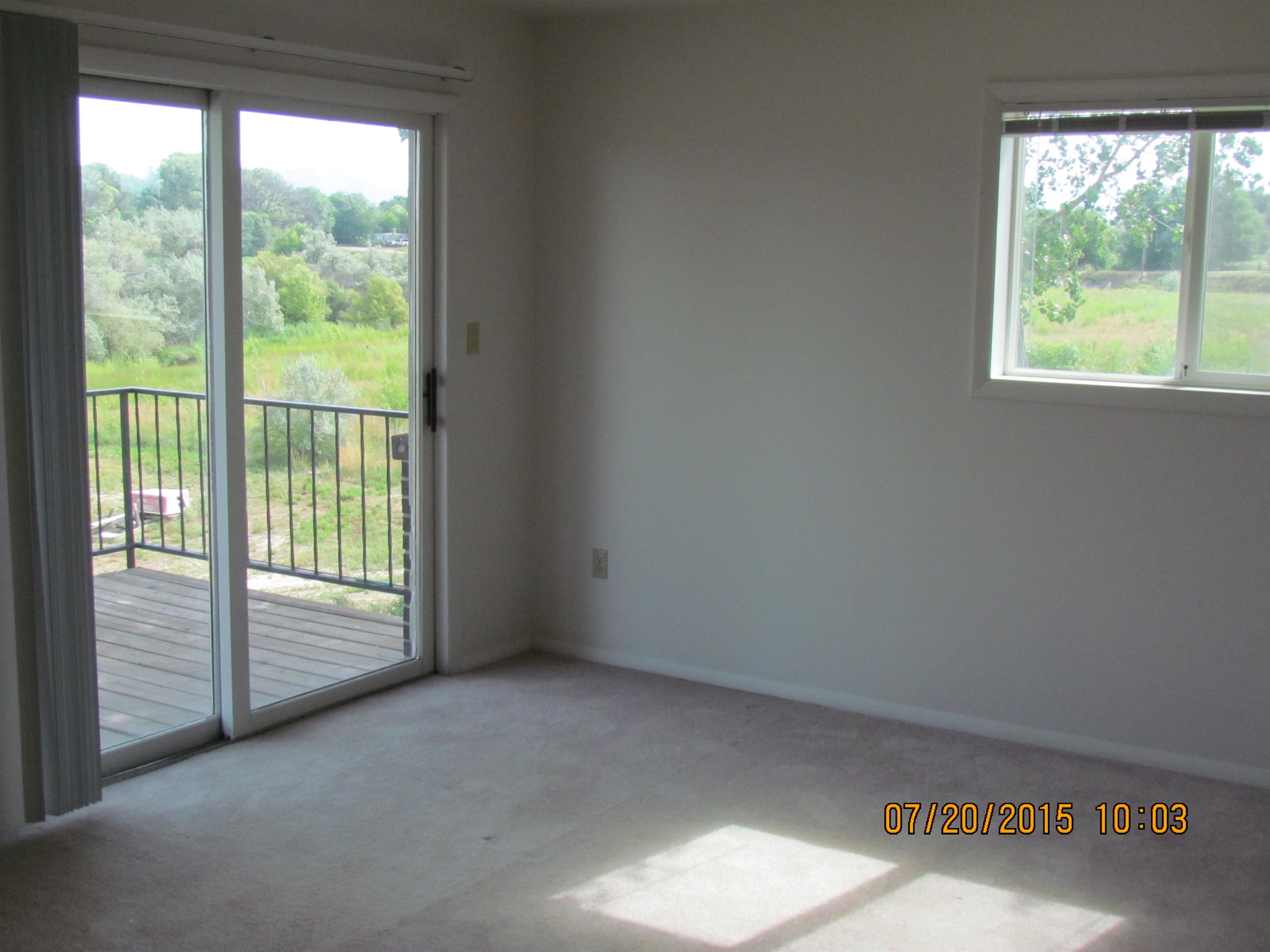 1179 17 Road Fruita, CO 81521 - Photo 14 of 41 a view of an empty room with wooden floor and a window