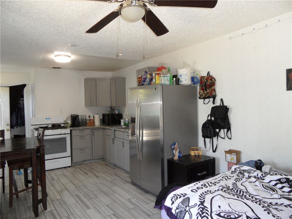 927 Daulton Avenue Madera, CA 93638 - Photo 32 of 34 a kitchen with stainless steel appliances granite countertop a refrigerator a stove a sink dishwasher and a dining table with wooden floor